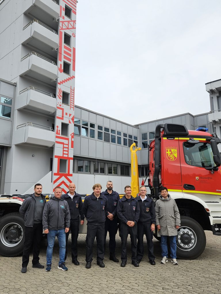 Beigeordneter Manuel Steinbrenner (1.v.r.), Jürgen-Heinrich Mayer als stellvertretender Leiter des Referats Feuerwehr (2.v.r.), Rüdiger Seifts als Abteilungsleiter Technik bei der Feuerwehr (3.v.l.) mit seinen Kollegen von der Technikabteilung sowie Vertreter der F&B Nutzfahrzeug-Technik GmbH (1. und 2.v.l.) freuen sich über die Übergabe des neuen Wechselladerfahrzeugs.