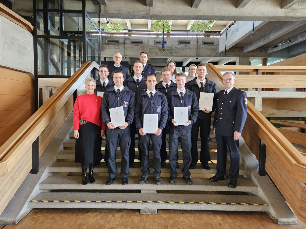 Die sieben neuen Feuerwehrmänner im Kreise ihrer Vorgesetzten, Ausbilder sowie Vertreterinnen und Vertretern von Personalreferat und Personalrat. Links vorne Oberbürgermeisterin Kimmel. Foto: Pressestelle der Stadt Kaiserslautern